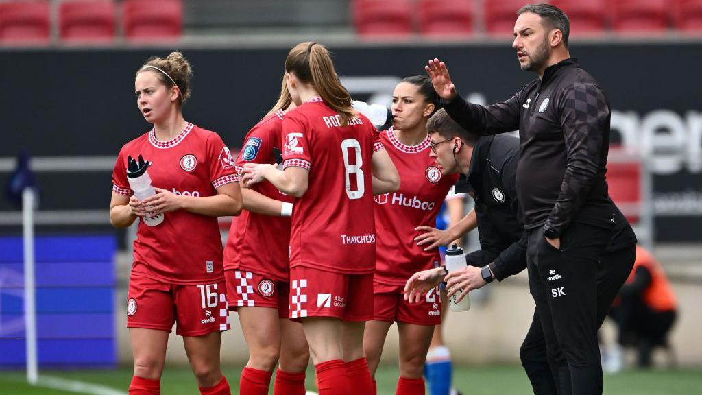 Stephen Kirby sur le bord du terrain avec des joueuses lors d'une pause contre Blackburn Rovers