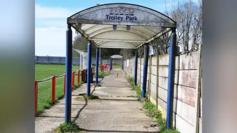 Teversal FC A Tesco trolley shelter is pictured in a football ground with goalposts and green grass in the background