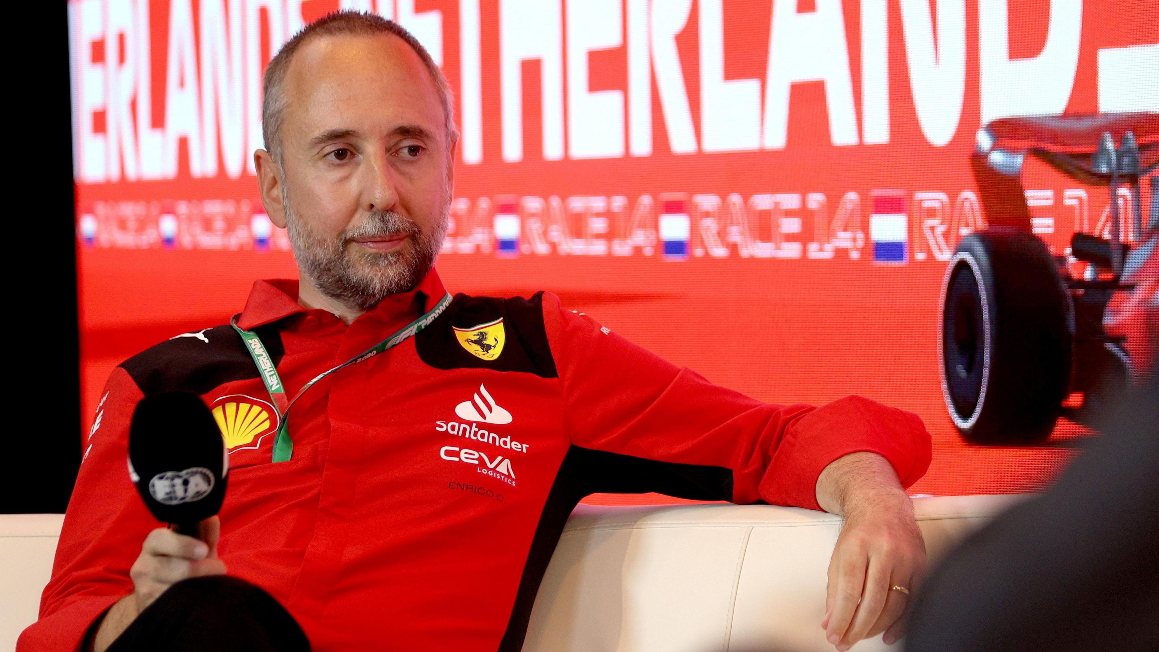 Enrico Cardile portant un haut Ferrari et tenant un microphone de marque FIA