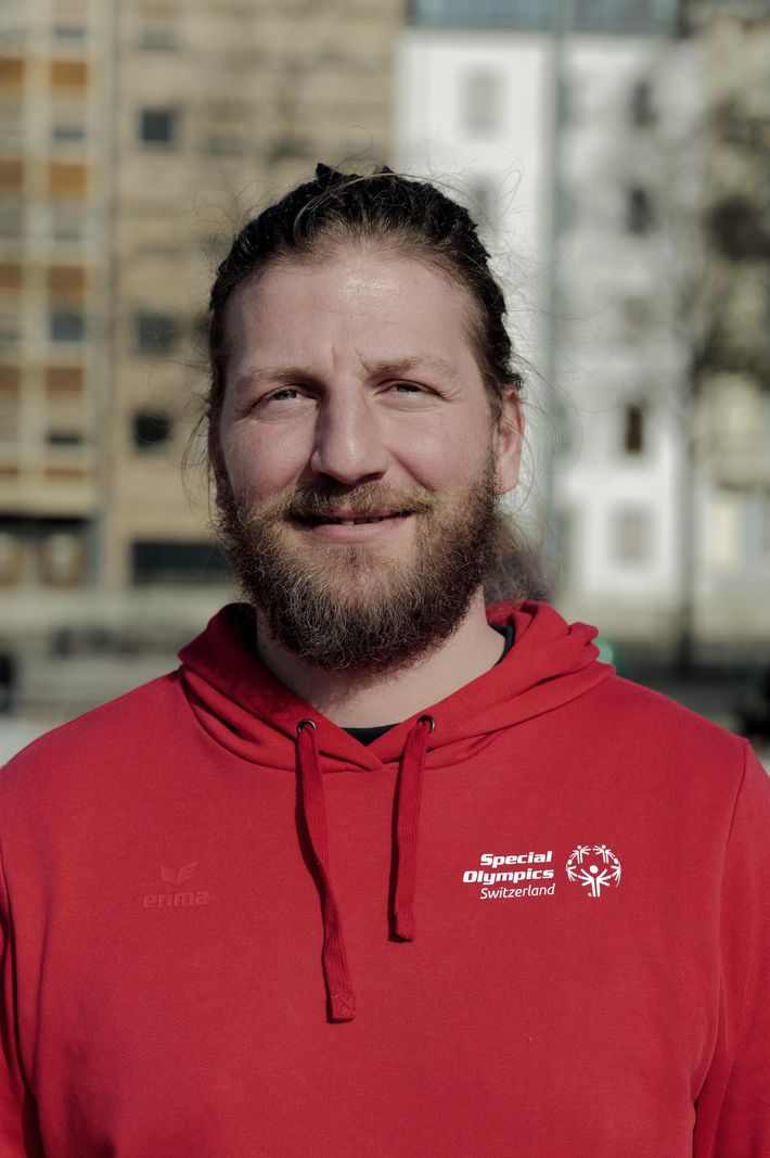 Jean-Camille Nonnat, coach de snowboard, portant un sweat à capuche rouge «Special Olympics Switzerland» à Plainpalais, Genève.