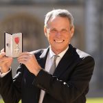Alan Hansen- légende du football- reçoit un MBE avec le sourire