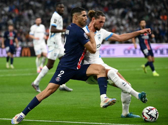Le défenseur parisien Achraf Hakimi à la lutte avec le milieu de terrain marseillais Adrien Rabiot lors du match de Ligue 1 entre le Paris Saint-Germain et l’Olympique de Marseille, le 27 octobre 2024, à Marseille.