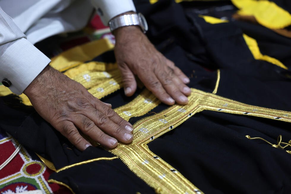 Le tailleur Habib Mohammed travaille examine la broderie d'un bisht, un long manteau orné et tissé à la main, dans son atelier de l'oasis de Hofuf, en Arabie saoudite, le 16 février 2025