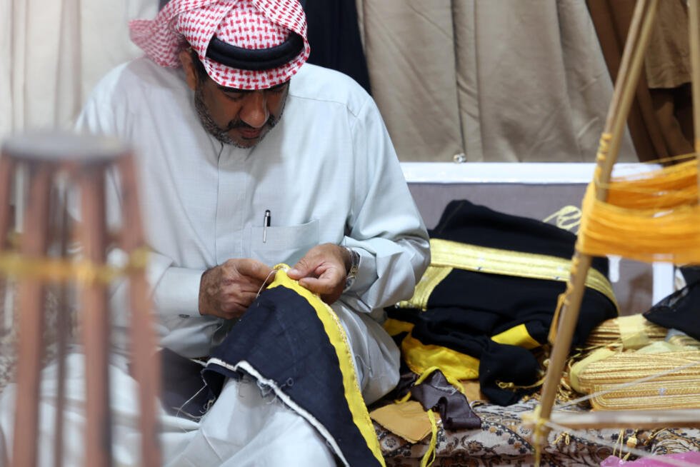 Le tailleur Habib Mohammed travaille sur la broderie d'un bisht dans son atelier de l'oasis de Hofuf, en Arabie saoudite, le 16 février 2025