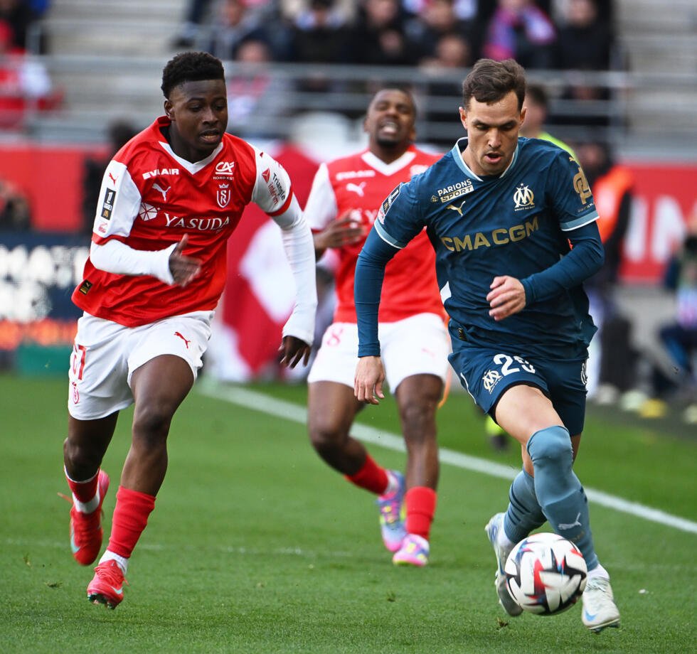 L'attaquant de Reims Mamadou Diakhon (g) et le Marseillais Pol Lirola lors de la victoire rémoise (3-1) en Ligue 1, le 29 mars 2025 au Stade Auguste-Delaune