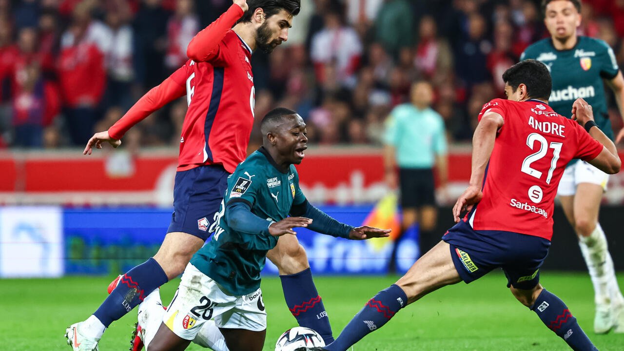 Le défenseur de Lens Nampalys Mendy (centre) chute après un duel avec les Lillois Angel Gomes (gauche) et Benjamin André (droite), lors de la 27e journée de L1, le 30 mars 2025 au stade Pierre-Mauroy