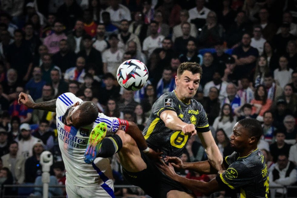 Le défenseur lillois Thomas Meunier (C) à la lutte avec le capitaine lyonnais Alexandre Lacazette, le 5 mars2025 à Décines-Charpieu