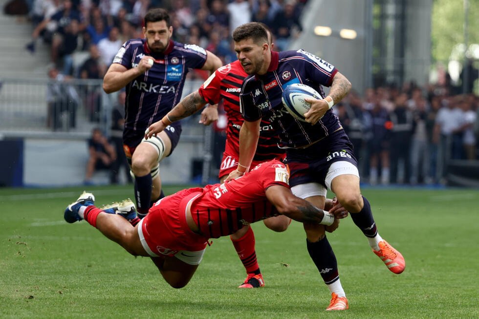 L'ouvreur de Bordeaux-Bègles Matthieu Jalibert (droite) plaqué par le Toulousain Pita Ahki (gauche) lors de la demi-finale de Champions Cup, le 4 mai 2025 à Bordeaux