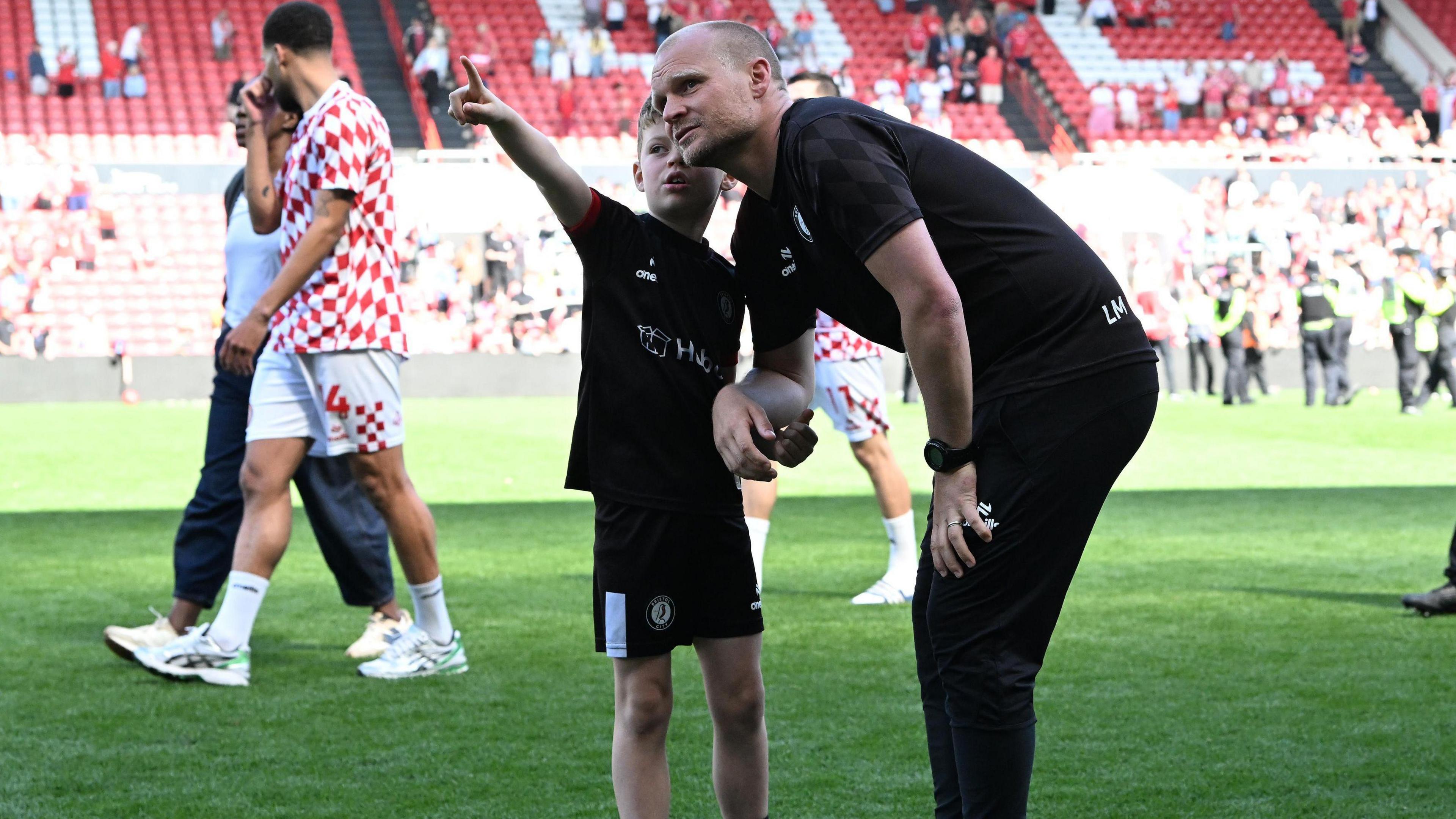 Liam Manning et son fils Isaac sur le terrain d'Ashton Gate