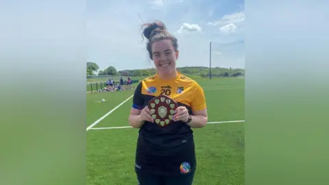 Caoimhe Mallon tenant un trophée en tenue de GAA