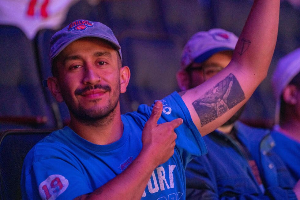 Un supporteur des Knicks de New York montre un tatouage en hommage à son équipe lors d'une retransmission d'un match au Madison Square Garden, à New York, le 14 mai 2025