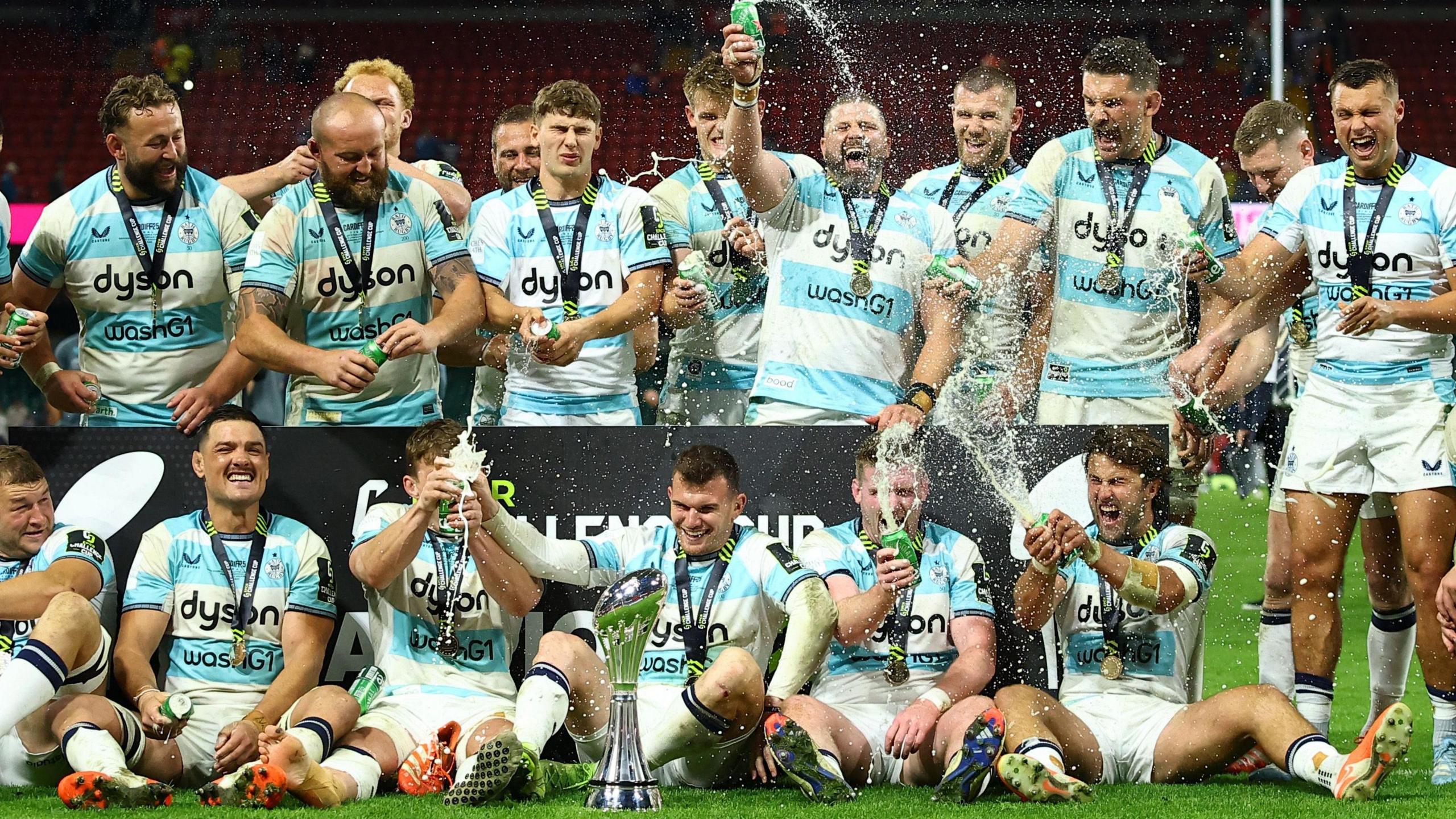 Les joueurs de Bath célèbrent leur victoire en versant du champagne autour de la coupe de la Challenge Cup