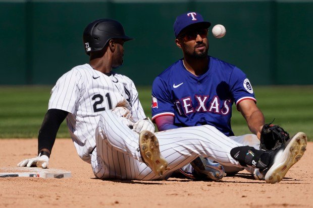 Chicago White Sox's Michael A. Taylor, left, est en sécurité au deuxième base avec un double face à la tentative de marquage tardif du deuxième base des Rangers, Marcus Semien, lors du neuvième inning du match de dimanche à Chicago. (AP Photo/David Banks)