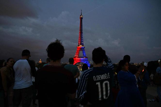 Une foule se rassemble devant la tour Eiffel illuminée aux couleurs du Paris Saint-Germain après sa victoire contre l’Inter Milan en finale de la Ligue des champions, à Paris, le 31 mai 2025.